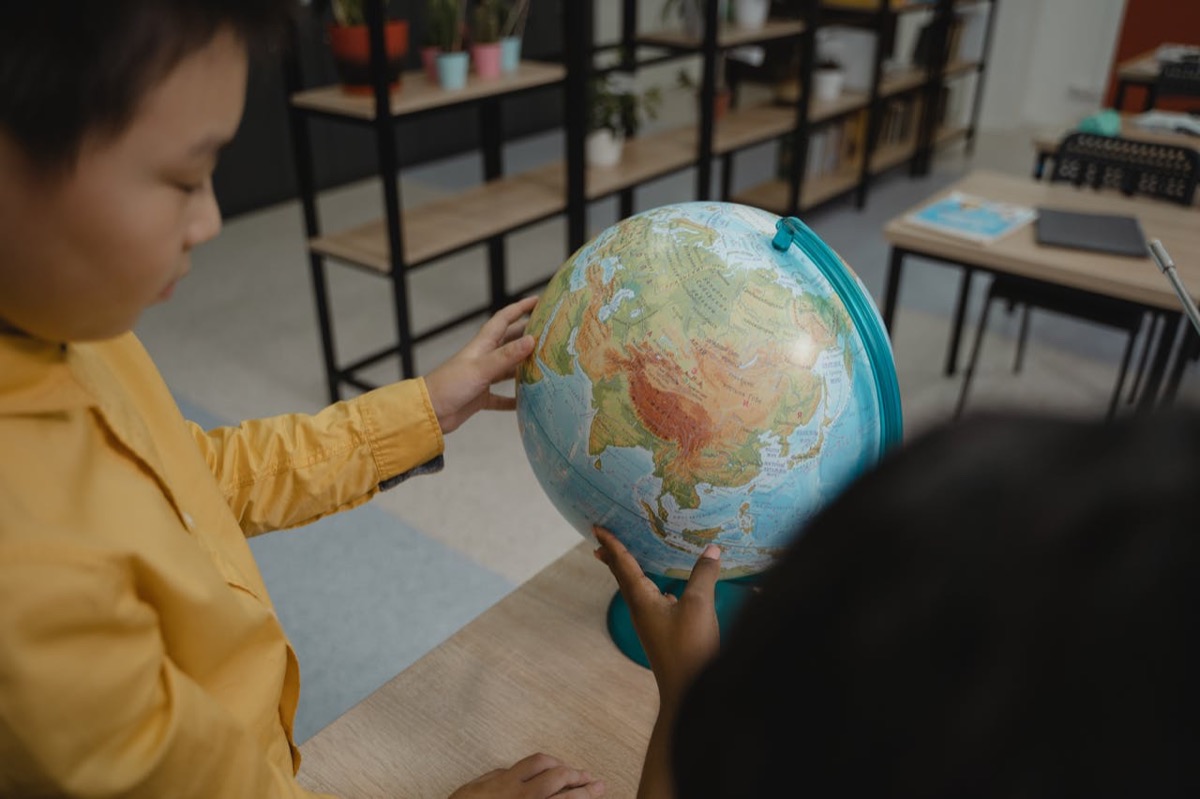Kinderen bekijken samen een wereldbol