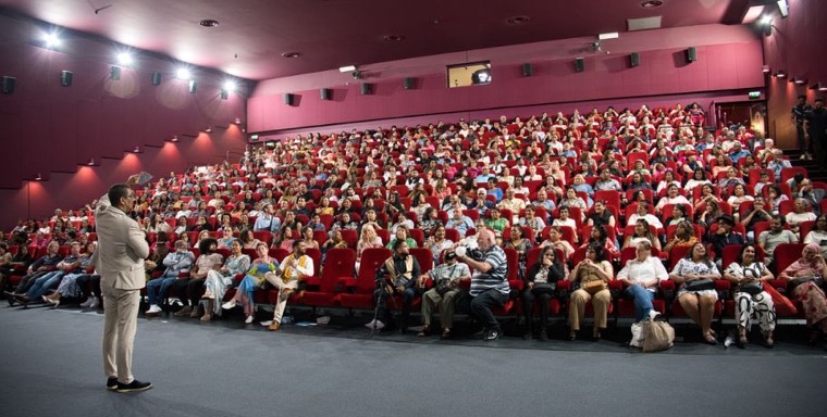 Volle zaal tijdens het evenement Vals Paradijs, met een spreker voor het publiek